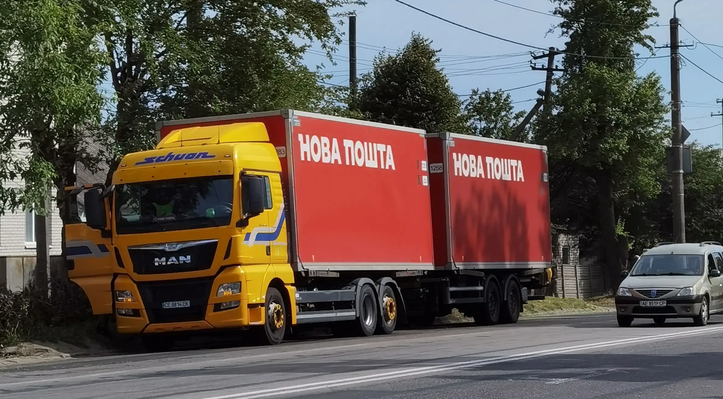 Вантажівка «Нова пошта» з червоним кузовом на вулиці